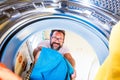 Close up of adult man cleaning and putting his clothes inside of the washing machine - man doing the housework Royalty Free Stock Photo