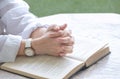 Close up of adult woman hands praying with open Holy Bible on octagon marble table in porch area at home Royalty Free Stock Photo