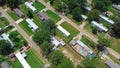 Close-up aerial low-density housing of mobile manufactured homes on large lot size, well-trimmed lawn, mature trees near Richland