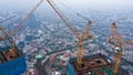 Close up aerial view of crane lowering an object on the roof of the skyscraper under construction in Jakarta, Indonesia