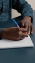 African american black person writing notes on notepad using a pen Royalty Free Stock Photo