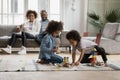 Close up African American kids playing together while parents relaxing Royalty Free Stock Photo