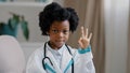 Close-up african american little girl standing in medical clothes playing pretending to be doctor charming child looking Royalty Free Stock Photo