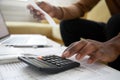 Close up of african american man with calculator checking bills Royalty Free Stock Photo