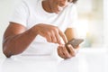 Close up of african american man hands using smartphone and smiling Royalty Free Stock Photo