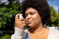 Close-up of african american mid adult woman using asthma inhale