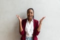 Close up African American Smiling Young Businesswoman making faces Wearing Jacket Looking at the Camera Against Gray Wall Royalty Free Stock Photo