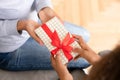 Close up African American teen girl presenting gift to mother Royalty Free Stock Photo