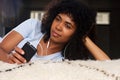 Close up african american young woman with smart phone and earphones Royalty Free Stock Photo