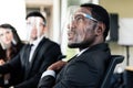 Close-up African businessman wearing a face shield, shares his opinion at a business group meeting, Discussion about year`s revie