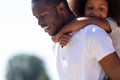 Close up african father giving little daughter piggyback ride Royalty Free Stock Photo