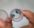 Close up on African male hand holding a plastic bottle with two medicine capsules Royalty Free Stock Photo