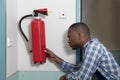 Male Professional Checking A Fire Extinguisher Royalty Free Stock Photo