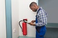 Male Professional Checking A Fire Extinguisher Royalty Free Stock Photo