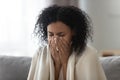 Close up african woman holding handkerchief blowing runny nose Royalty Free Stock Photo