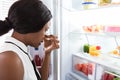 Woman Holding Her Nose Near Foul Food In Refrigerator