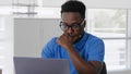 Close up of afro-american pensive employee working on laptop in office Royalty Free Stock Photo