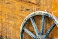 Close-up of age weathered wagon wheel with wooden spokes leaning Royalty Free Stock Photo