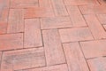 Close-up of an aged brick paved courtyard, a pattern of clay brick lay to for pattern zigzag style