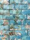 Close-up of aged brickwork showcases a detailed texture of blue paint slowly succumbing to time's relentless Royalty Free Stock Photo