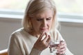 Close up of aged female holding water and medicines Royalty Free Stock Photo