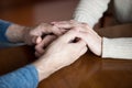 Close up of elder couple holding hands giving support