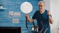 Close up of aged man doing cycle exercise on static bicycle Royalty Free Stock Photo