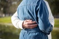 Close-up of aged mans hand hugging woman in park