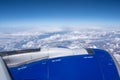 Close up of airplane engine with snow mountains and clouds in the background