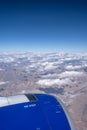 Close up of airplane engine with snow mountains and clouds in the background