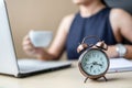 Close up alarm clock with young Businesswoman using laptop analysis marketing plan and drinking coffee in the morning. Business,