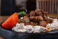 Close up of a Alinazik kebab on a black plate