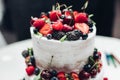 Close-up amazing fresh appetizing sweet cake with cream covered by refreshing fruit and berries