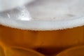 Close up of a amber beer or ale foam on the top of a beer pint glass  on a sunny day. Selective focus Royalty Free Stock Photo