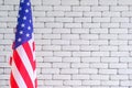 Close-up of the America flag against white brick wall background Royalty Free Stock Photo