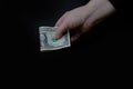 Close-up of American dollars in a female hand on black background, concept of tip money, change of waiter, saving on food Royalty Free Stock Photo