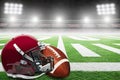 American Football and Helmet on Field With Stadium Lights and Copy Space Royalty Free Stock Photo