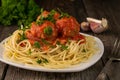 Close-up of American spaghetti with meatballs and tomato sauce with garlic and onions on a rustic wooden background Royalty Free Stock Photo