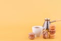 Close-up of Americano coffee, jezva, coffee pot and almond cookies on yellow background