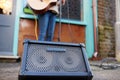 Close Up Of Amplifier As Female Musician Busks Playing Acoustic Guitar Outdoors In Street Royalty Free Stock Photo