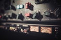 Close-up amplifier equipment with sliders and knobs at boutique recording studio.