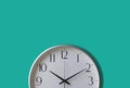 white clock isolated on mint green wall background. Royalty Free Stock Photo