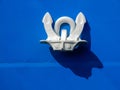 Close up of an anchor on blue a ship`s hull. Royalty Free Stock Photo