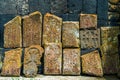 Close-up of ancient stone khachkars with carved lace patterns on the walls of a monastery