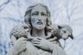 Close up ancient stone statue of Jesus Christ Good Shepherd with the lost sheep on his shoulders Royalty Free Stock Photo