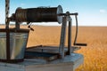 Close-up of ancient water well on background of wheat field. Royalty Free Stock Photo