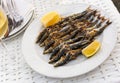 Close up of Andalusian fried sardines on white plate on white tablecloth