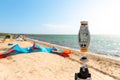 Close-up anemometer wind meter gadget against surf kite equipment on sand beach shore watersport spot on bright sunny