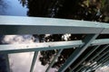Close up angled photo of a grey steel railing on a bridge.
