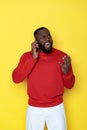 Close up of angry African man screaming by smartphone in studio Royalty Free Stock Photo